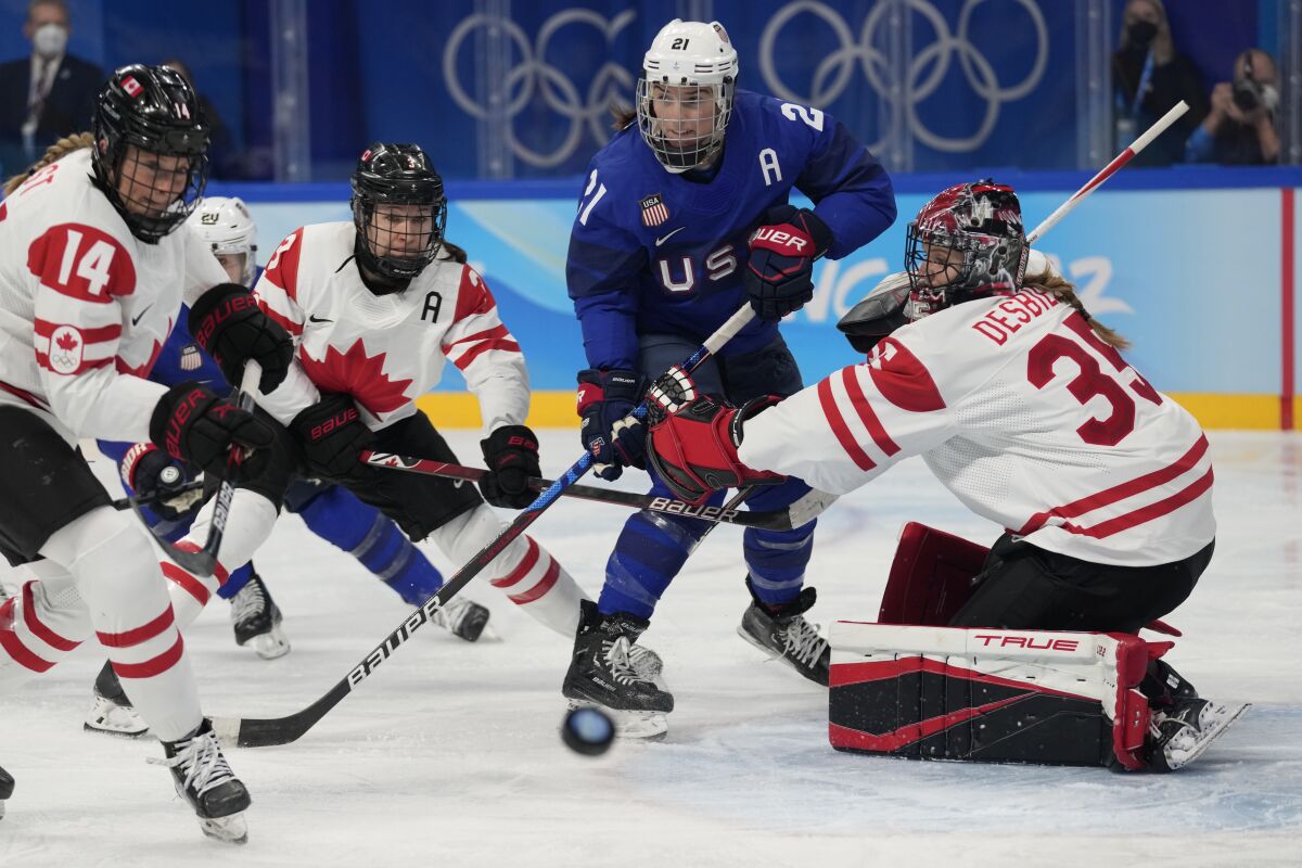 Canada goaltender Ann-Renee Desbiens blocks a shot in front of United States forward Hilary Knight.