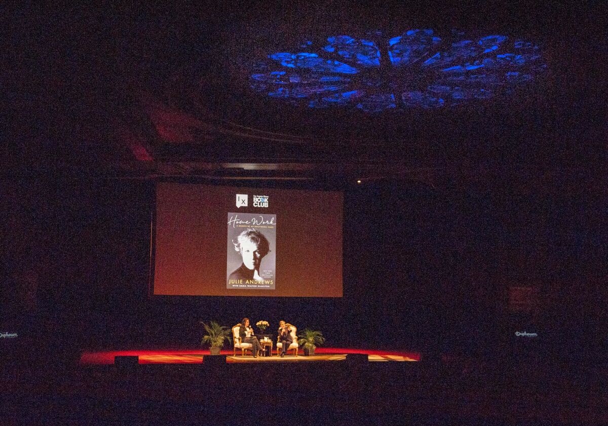Mary McNamara, left, and Julie Andrews onstage, with an image of the cover of Andrews' book "Home Work" on a screen overhead.