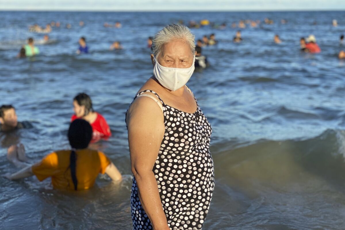 A woman stands on a beach in the city of Vung Tau in Vietnam.