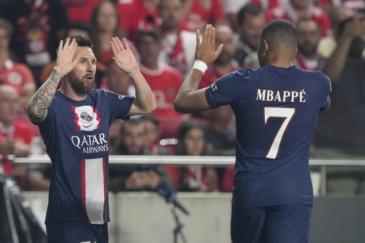 PSG's Lionel Messi, left, celebrates with PSG's Kylian Mbappe after scoring during the Champions League group H soccer match between SL Benfica and Paris Saint-Germain at the Luz stadium in Lisbon, Wednesday, Oct. 5, 2022. (AP Photo/Armando Franca)