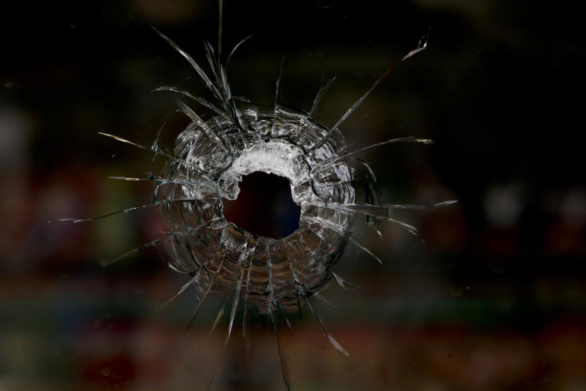 A bullet hole in the window of the IV Deli Mart in the aftermath of the May 24 Isla Vista shootings in which seven people, including the gunman, died. A new law would allow police to temporarily seize guns from those who may be on the verge of committing such violence.