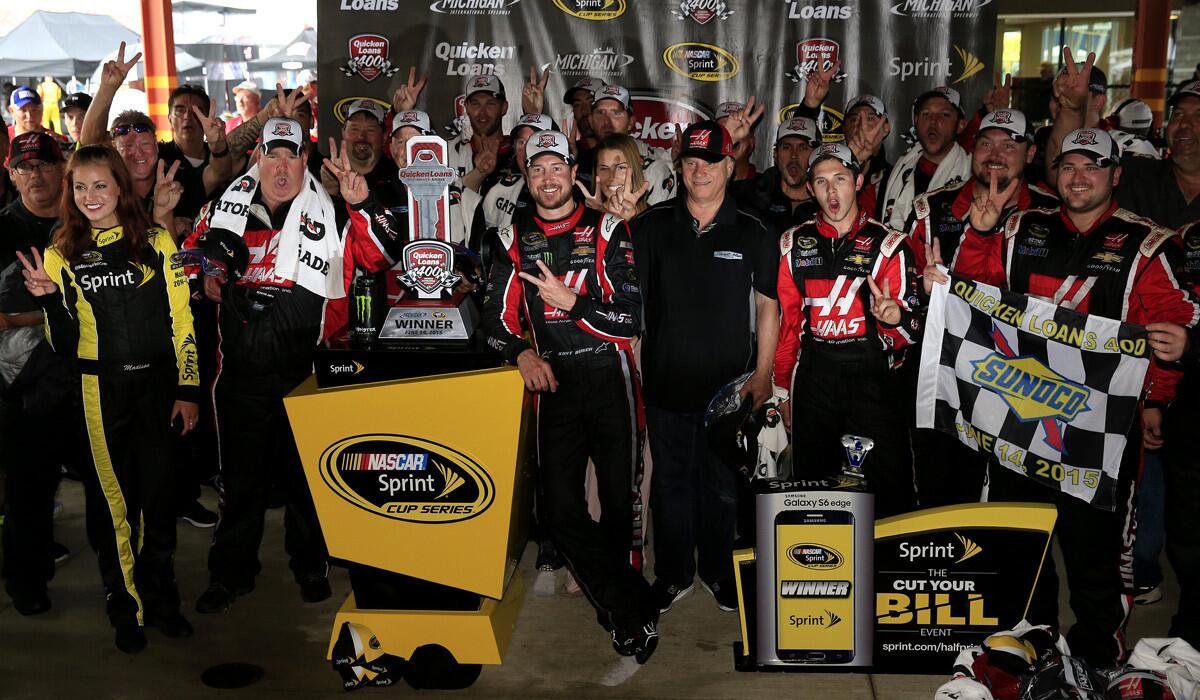 Kurt Busch and his team pose in an alternate Victory Lane after winning the NASCAR Sprint Cup Series Quicken Loans 400 at Michigan International Speedway on Sunday in Brooklyn, Michigan.