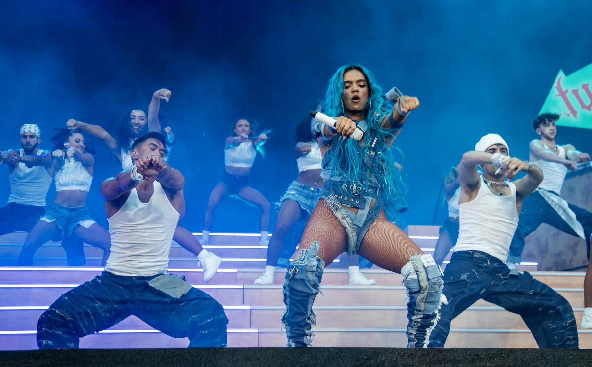 With her bright blue hair, Karol G performs with two dancers on Coachella's main stage. 