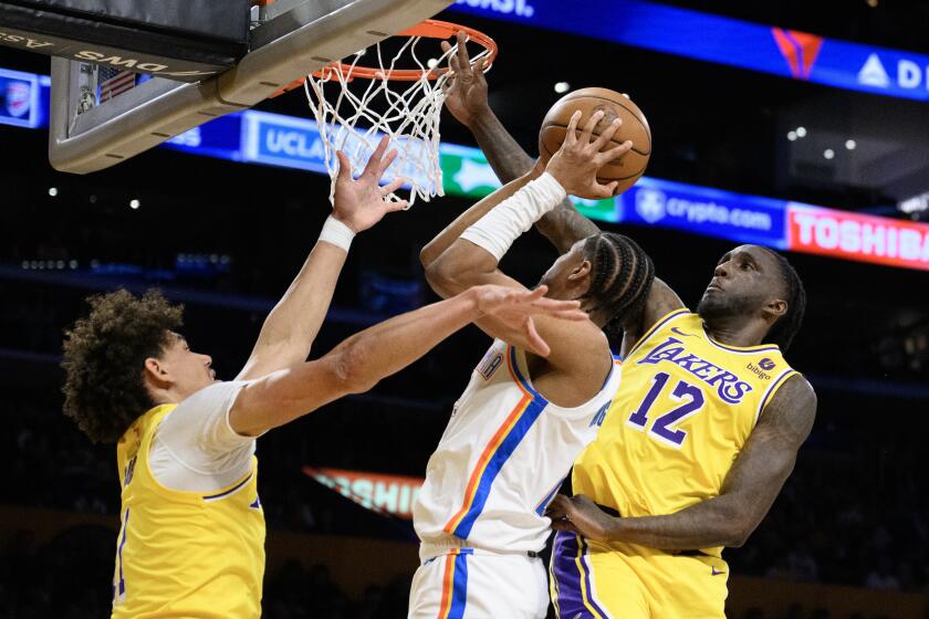 Lakers forward Taurean Prince and center Jaxson Hayes try to block a shot by Oklahoma City Thunder guard Aaron Wiggins.