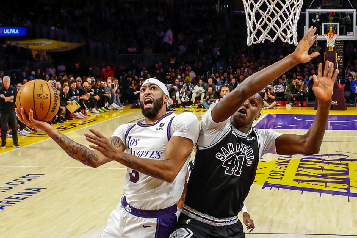 Lakers forward Anthony Davis, left, shoots under pressure from San Antonio Spurs forward Gorgui Dieng.