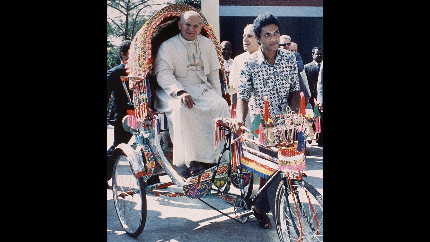 Pope John Paul II rides in a rickshaw at the Vatican Mission in Dhaka, Bangladesh, on Nov. 19, 1986.
