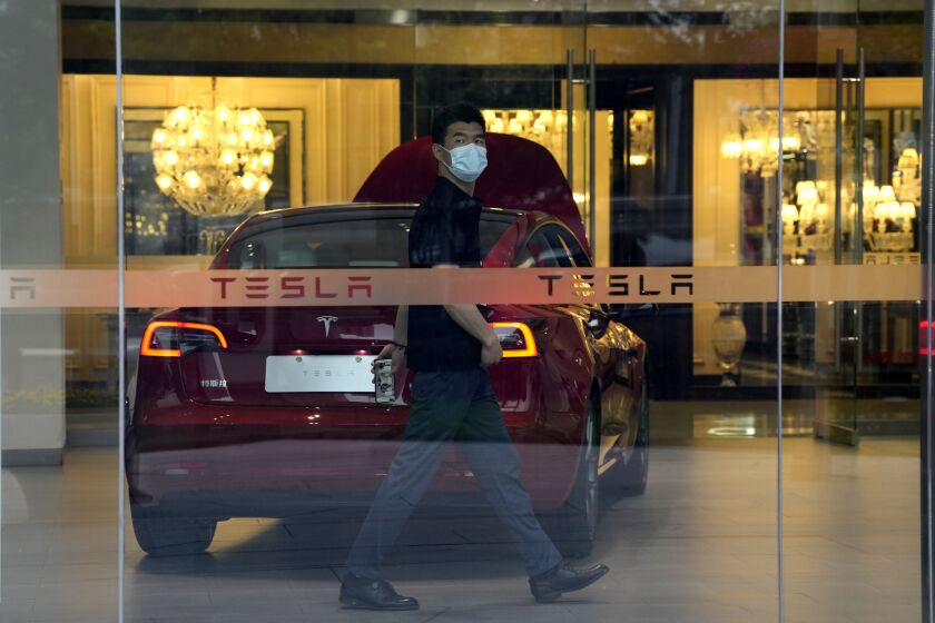 A worker walks in a Tesla showroom in Beijing, Tuesday, May 30, 2023. China’s foreign minister met Tesla Ltd. CEO Elon Musk on Tuesday and said strained U.S.-Chinese relations require “mutual respect,” while delivering a message of reassurance that foreign companies are welcome. (AP Photo/Ng Han Guan)