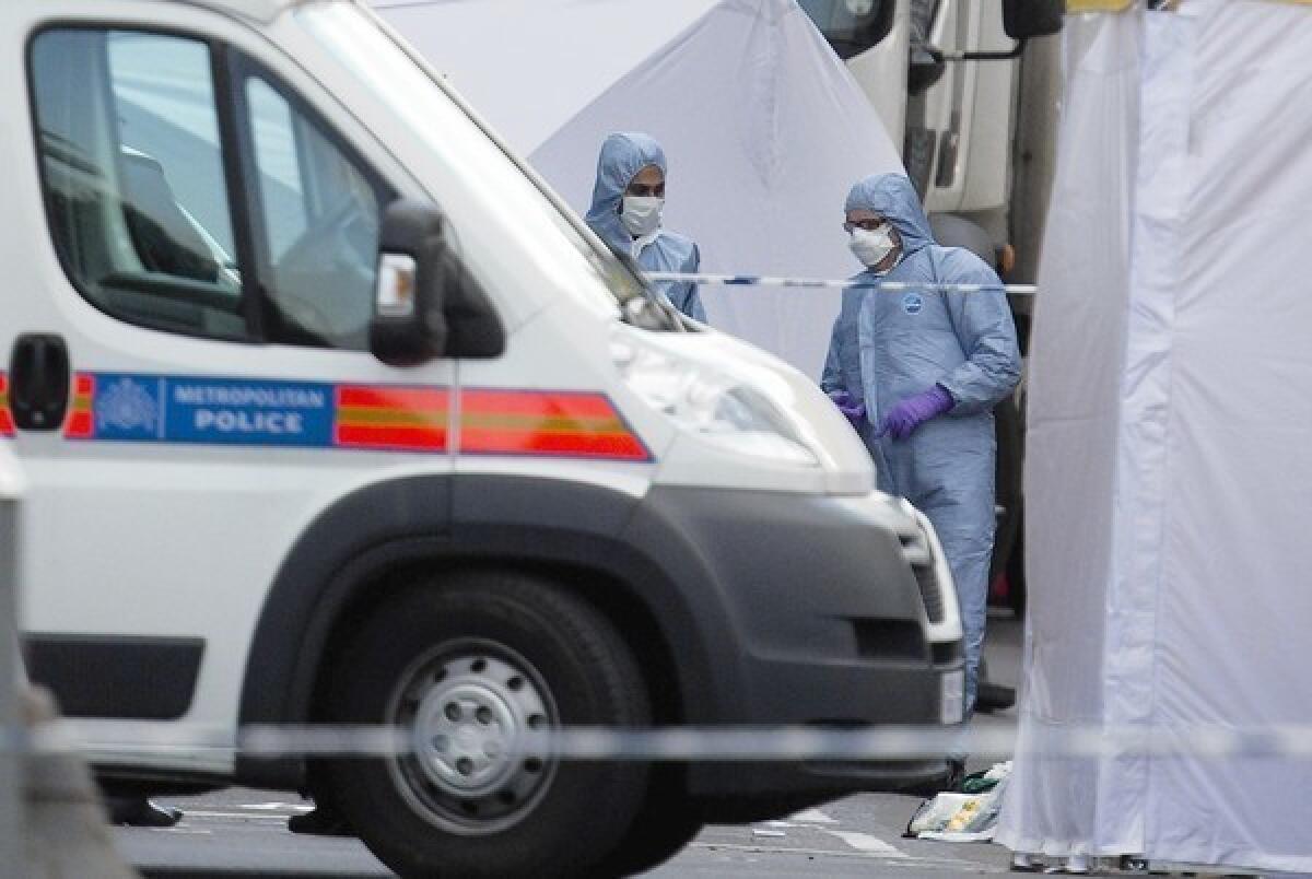 British forensic officers at work at the scene of the brutal attack that left one man dead in Woolwich, in southeast London.