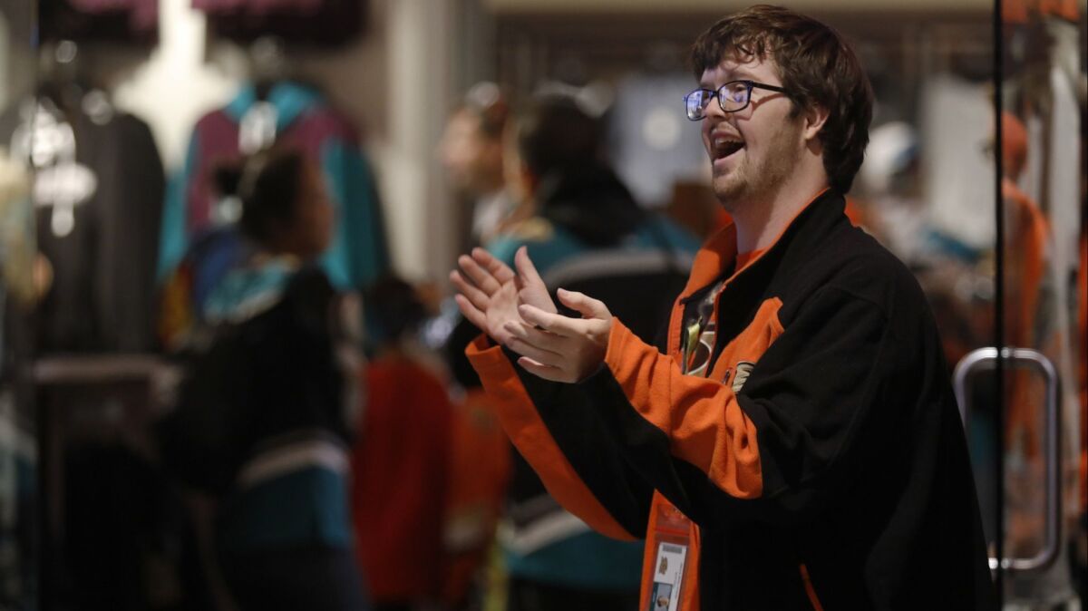 Trevor Hendershot stands outside the team store for the Ducks at Honda Center. He has Down syndrome and works as a greeter at the team stores of the Ducks, Angels, Rams and USC.