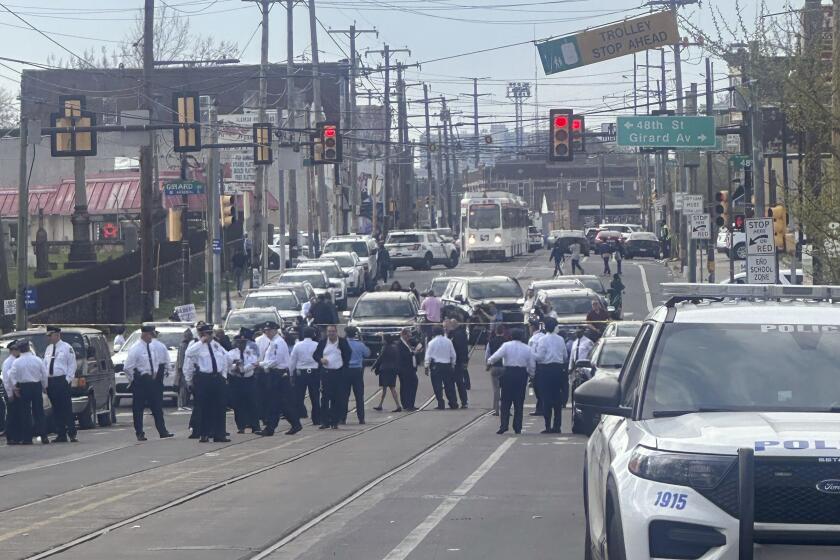 Police and officials gather on a cordoned off street at the scene of a shooting, Wednesday, April 10, 2024, in Philadelphia. (AP Photo/Claudia Lauer)
