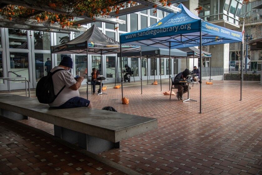 Patrons use the San Diego Central Library's socially distanced outdoor computer lab.
