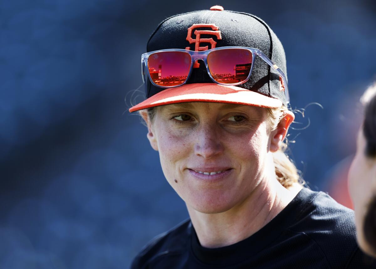 Alyssa Nakken smiles while wearing a baseball cap with sunglasses perched on it.