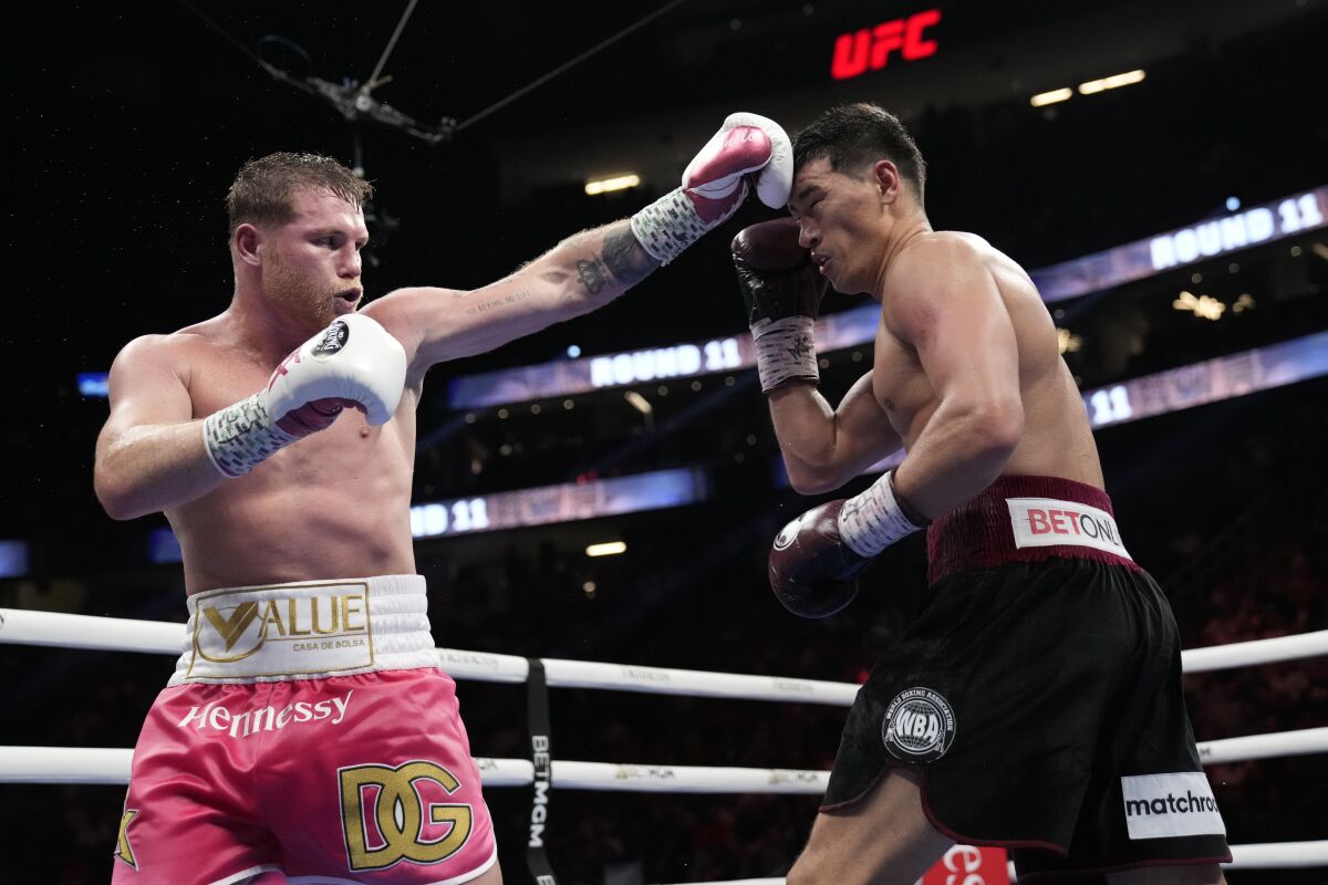 Canelo Alvarez, left, of Mexico throws a punch against Dmitry Bivol.