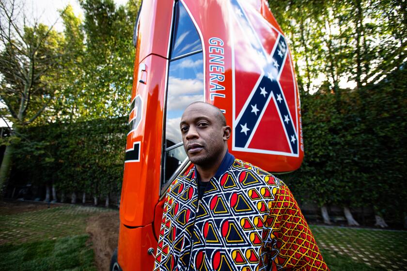 Los Angeles, CA., January 16, 2020 — Hank Willis Thomas poses for a portrait at the Kayne Griffin Corcoran Gallery on Thursday, January 16, 2020 in Los Angeles, California. In his first L.A. show at Kayne Griffin Corcoran, Willis, a New York-based artist takes on issues of representation in Hollywood, including a sculpture of a life-sized General Lee from "The Dukes of Hazzard." Thomas played with a toy version as a child, and now as an adult, he looks at the significance of a young black boy playing with Confederate symbols. The sculpture is titled "A Suspension of Hostilities," 2019. (Jason Armond / Los Angeles Times)