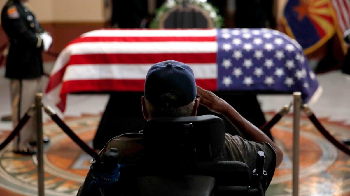 A veteran salutes the casket of Sen. John McCain at the Arizona state Capitol in Phoenix on Wednesday.