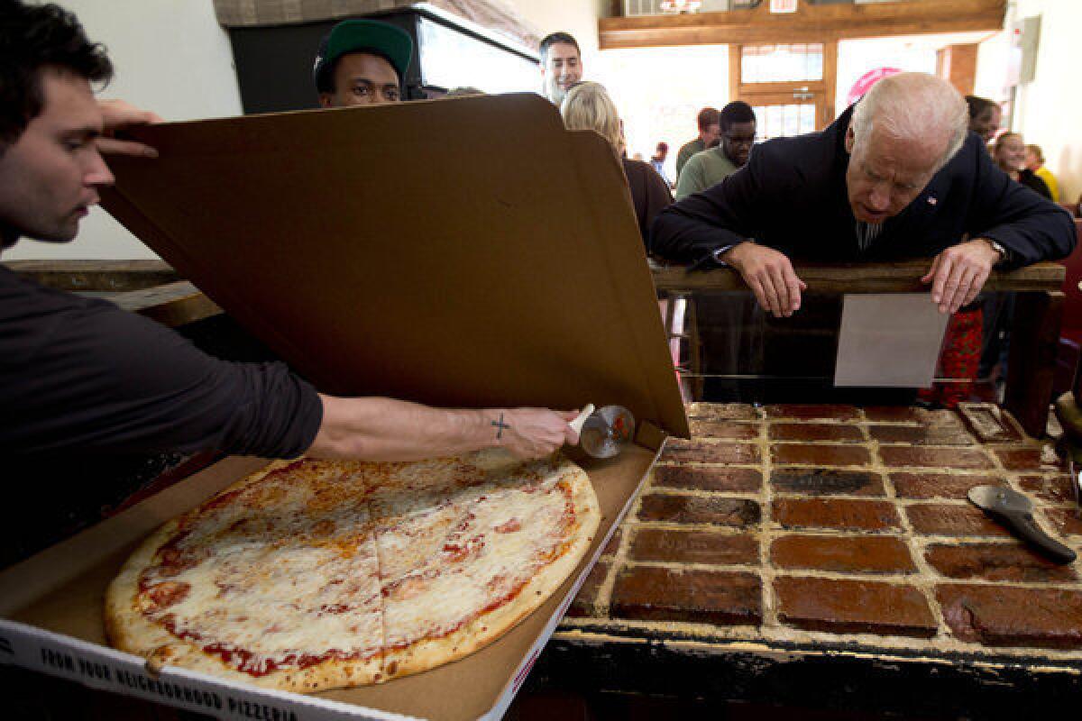 Vice President Joe Biden watches as a Benny Marconi's employees cuts a pizza in Roanoke, Va.