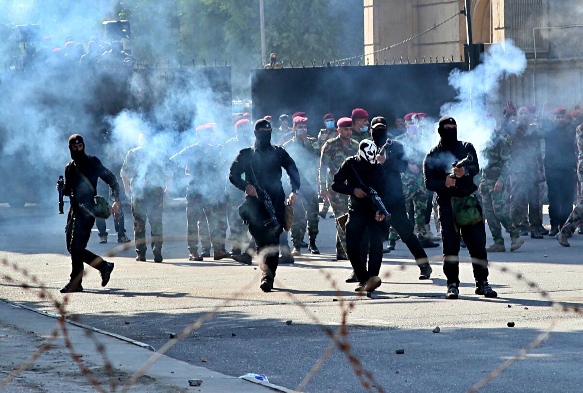 Iraqi security forces fire tear gas toward anti-government protesters in Baghdad on Friday.