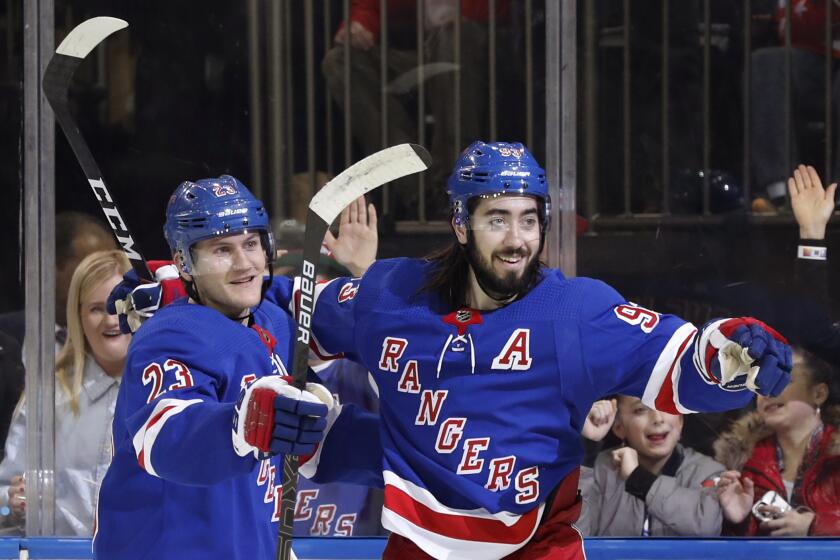 New York Rangers defenseman Adam Fox (23) and center Mika Zibanejad (93) celebrate as they wait for a teammate to join them after Zibanejad scored a goal during the second period of the team's NHL hockey game against the Washington Capitals, Thursday, March 5, 2020, in New York. (AP Photo/Kathy Willens)