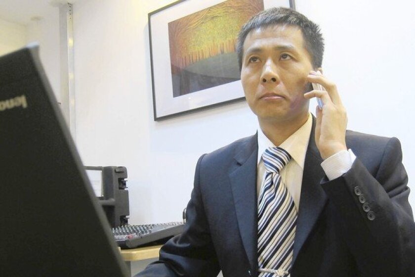 Zhu Ruifeng, who runs a Chinese website exposing official corruption, fields telephone calls in Beijing after his latest expose.