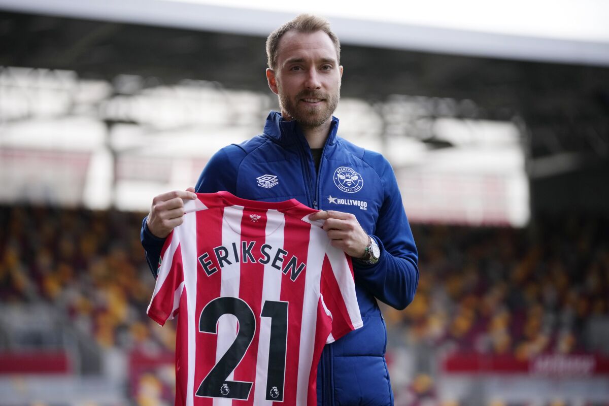 Brentford's newly signed Danish player Christian Eriksen poses for photographs with a team shirt during his official presentation at the Community Stadium, in London, Friday, Feb. 11, 2022. Eriksen has signed with Brentford until the end of the season, almost eight months after collapsing from cardiac arrest at the European Championship. It will be a remarkable playing comeback to the English Premier League for the Denmark playmaker, who has said he was essentially dead for five minutes after collapsing in the opening Euro 2020 game against Finland. (AP Photo/Matt Dunham)