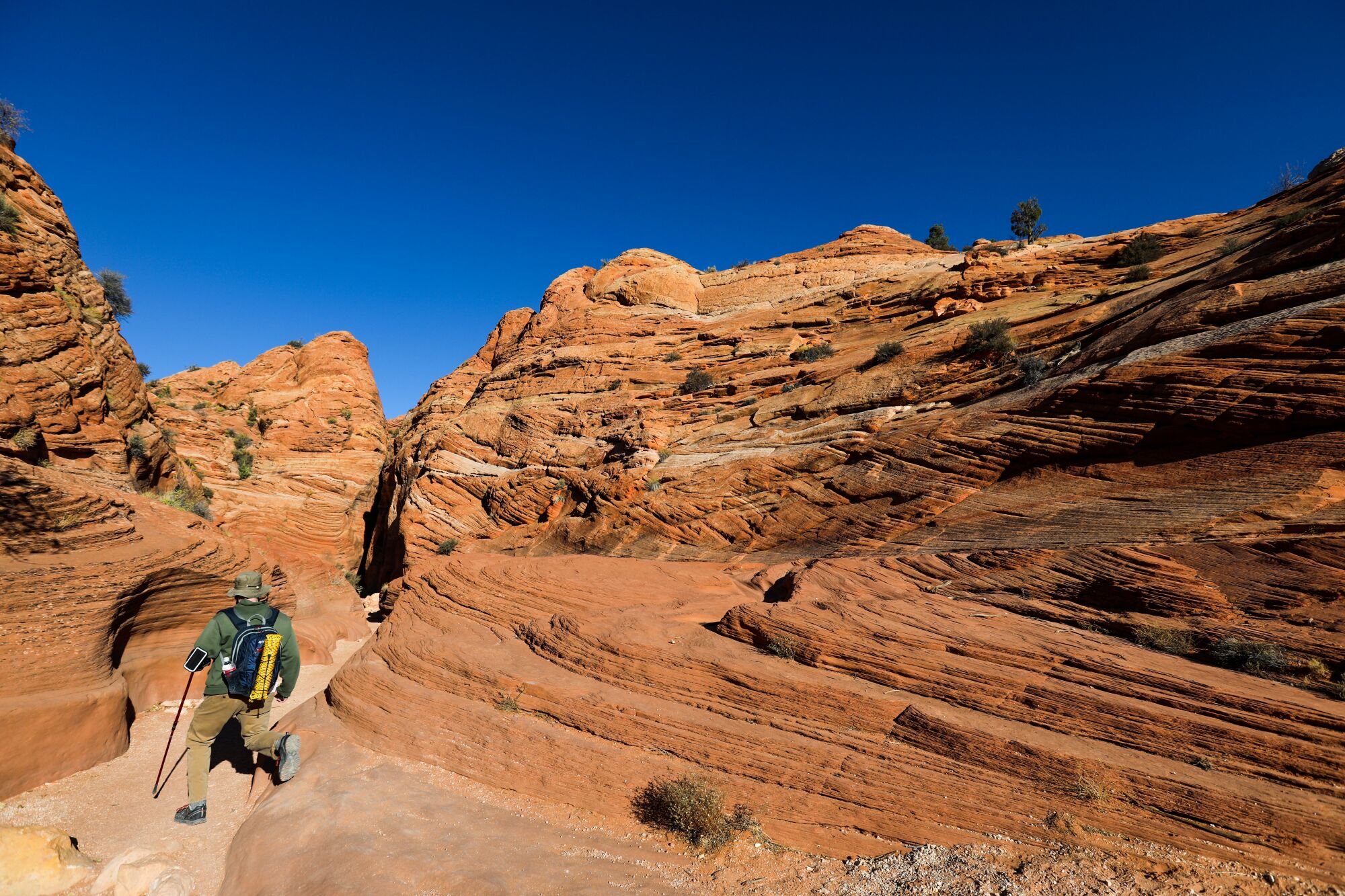 A man hikes through desert rocks