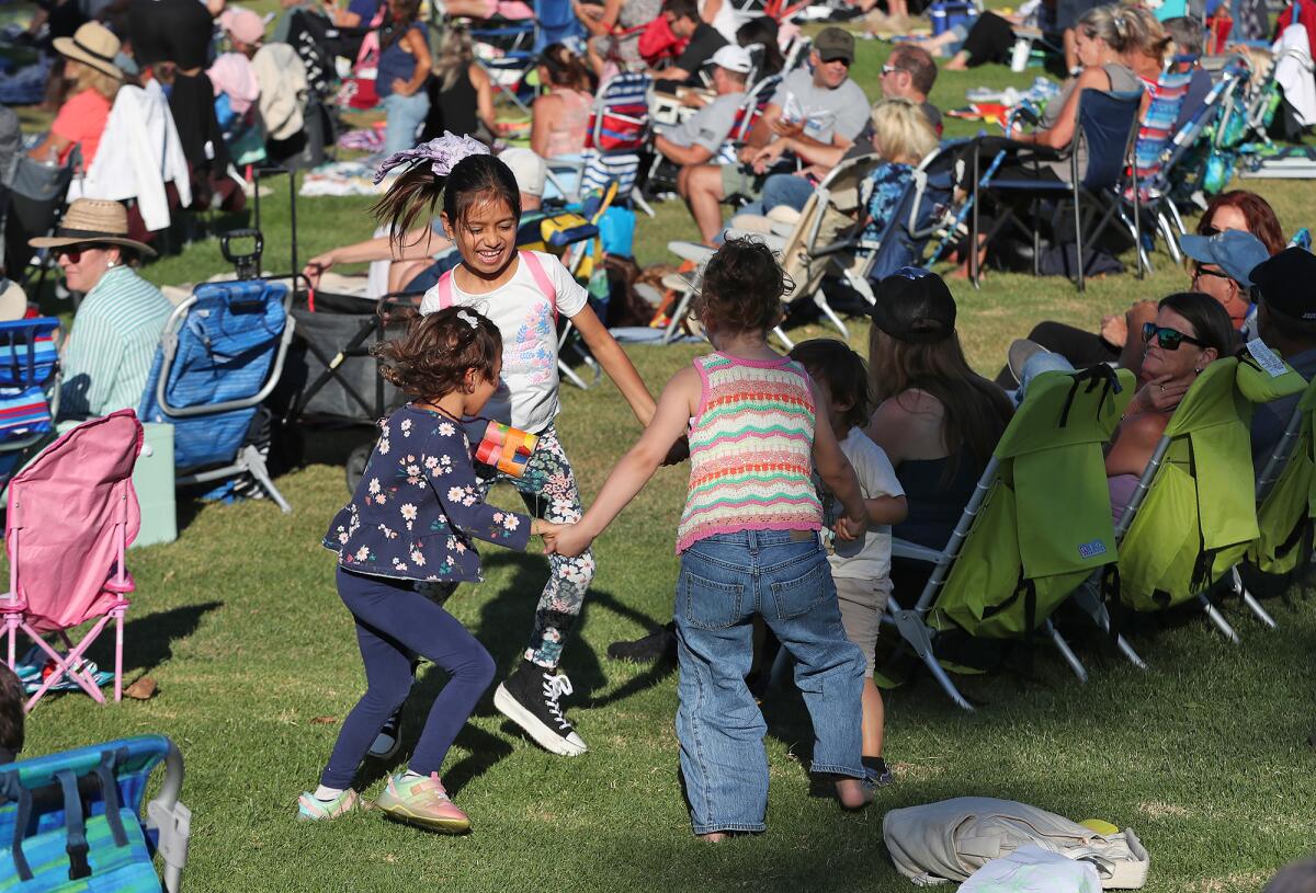 Kids dance to the Family Style band during Costa Mesa's annual Concerts in the Park series Tuesday.