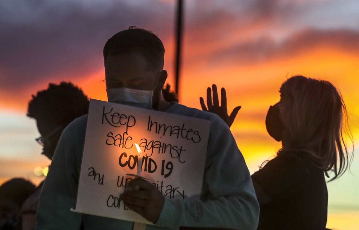 Family members of prison inmates in Utah hold candles following a rally in Draper.