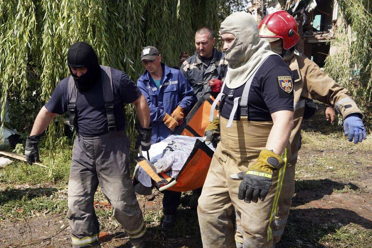 Men carry a body in Ukraine