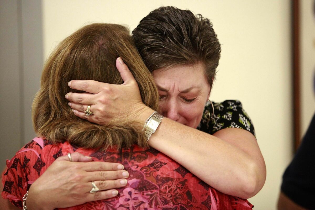 Vienneau's mother, Dayna Herroz (right), tearfully embraced her sister, Jodi Mickelson, in the courtroom. (John Gibbins / Union-Tribune)