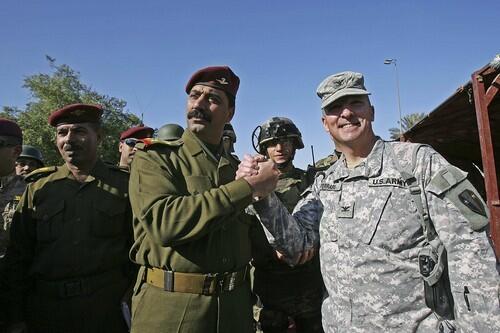 U.S. Col. Steven Ferrari, a commander of the Joint Area Support Group Baghdad, clasps hands with Brig. Emad Yaseen, commander of the Iraqi army's Baghdad Brigade, during a hand-over ceremony in the the city's Green Zone.