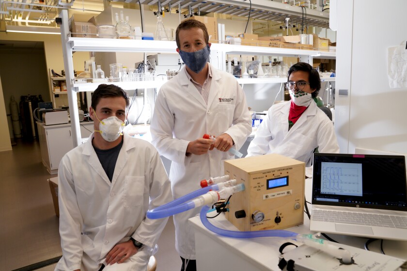 Kevin Wood, SDSU assistant professor, shows his design for an inexpensive ventilator with Tyler Lestak and Ener Arvizu Muoz.