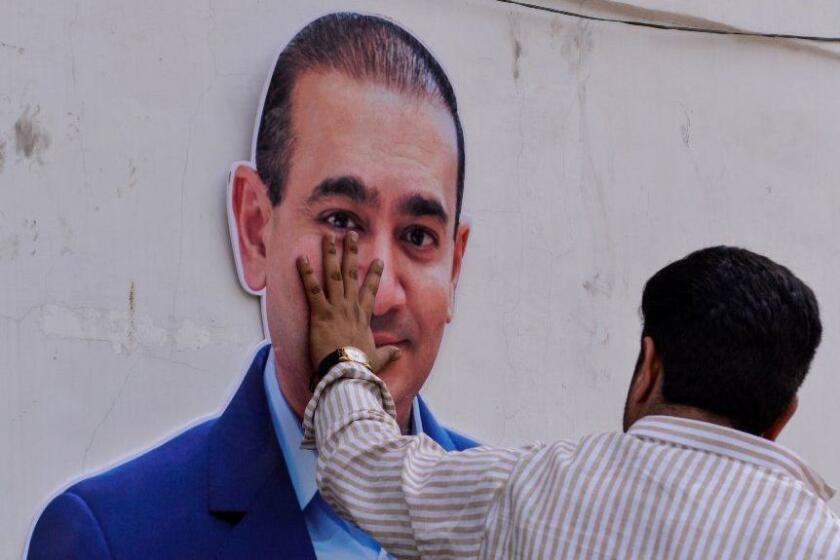 An Indian supporters of the Congress Party keeps his hand on the face of a cut out of billionaire jeweller Nirav Modi during a protest in New Delhi on February 16, 2018. Indian investigators on February 15 raided the premises of a billionaire jeweller accused of defrauding one of the country's biggest banks. Enforcement Directorate (ED) officers searched the Mumbai offices of Nirav Modi after he was accused of cheating state-owned Punjab National Bank (PNB) of 2.8 billion rupees ($43.8 million). / AFP PHOTO / CHANDAN KHANNACHANDAN KHANNA/AFP/Getty Images ** OUTS - ELSENT, FPG, CM - OUTS * NM, PH, VA if sourced by CT, LA or MoD **