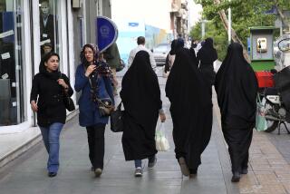 FILE - Iranian women make their way along a sidewalk in downtown Tehran, Iran, Tuesday, April 26, 2016. Iranian police have announced a new campaign to force women to wear the Islamic headscarf. Morality police returned to the streets on Sunday, 10 months after the death of a woman in their custody sparked nationwide protests. (AP Photo/Vahid Salemi, File)