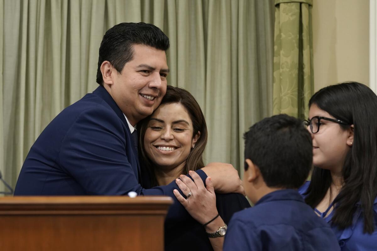 David Alvarez hugs his wife, Xochitl, after he was sworn into the California Assembly 