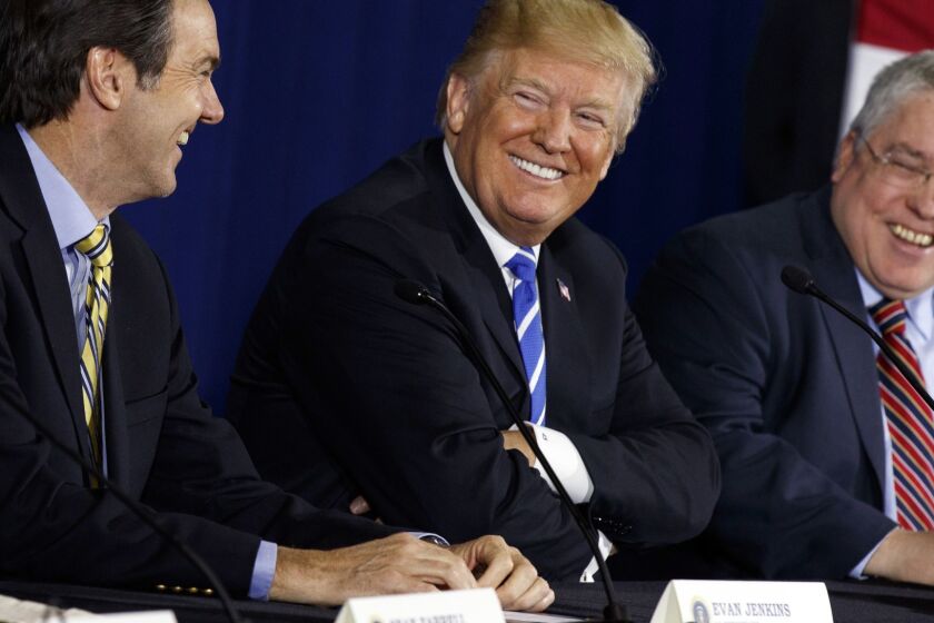 FILE - In this April 5, 2018, file photo, U.S. President Donald Trump smiles during a roundtable discussion on tax policy, in White Sulphur Springs, W.Va., with U.S. Rep. Evan Jenkins, R-W.Va., left, and West Virginia Attorney General Patrick Morrisey. Voters in the heart of Trump country are ready to decide the fate of West Virginia Republican Senate candidate Don Blankenship, a brash businessman and GOP outsider with a checkered past who is testing the success of President Donald Trumpâs playbook in one of the nationâs premiere Senate contests. (AP Photo/Evan Vucci, File)