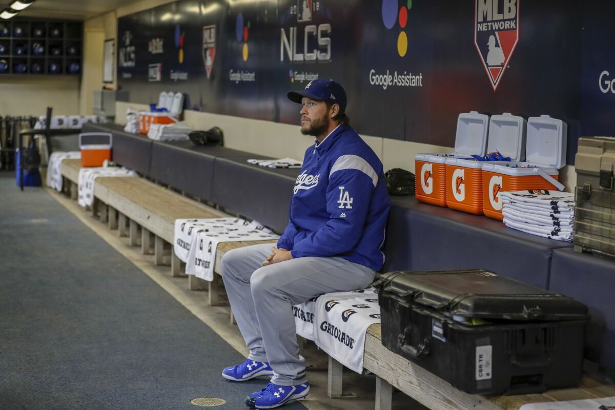 Dodgers pitcher Clayton Kershaw sits alone in the dugout for a few moments before heading to the outfield for pregame warmups in Game 1 of the National League Championship Series at Miller Park.