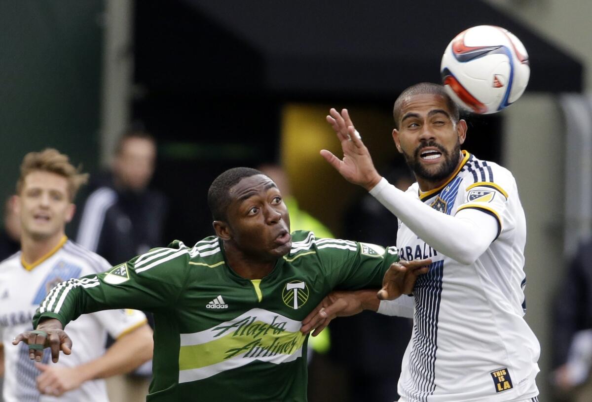 Galaxy defender Leonardo, right, heads the ball away from Timbers forward Fanendo Adi during the second half of their game last week in Portland, Ore.
