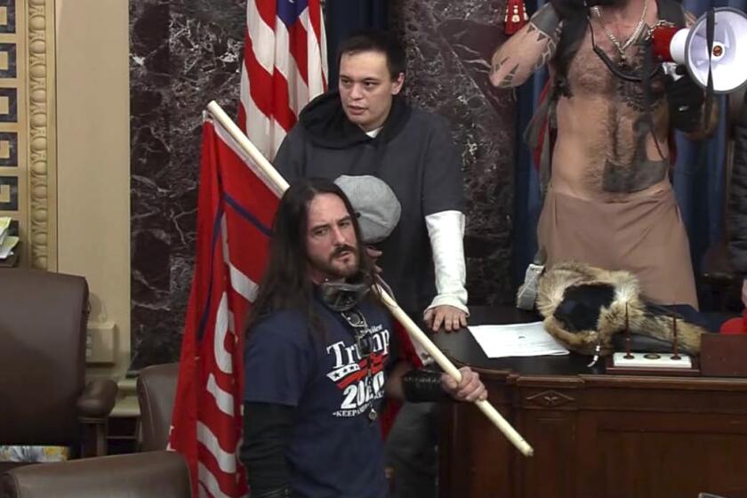 FILE - In this file image from U.S. Capitol Police video, Paul Allard Hodgkins, 38, of Tampa, Fla., front, stands in the well on the floor of the U.S. Senate on Jan. 6, 2021, at the Capitol in Washington. (U.S. Capitol Police via AP, File)
