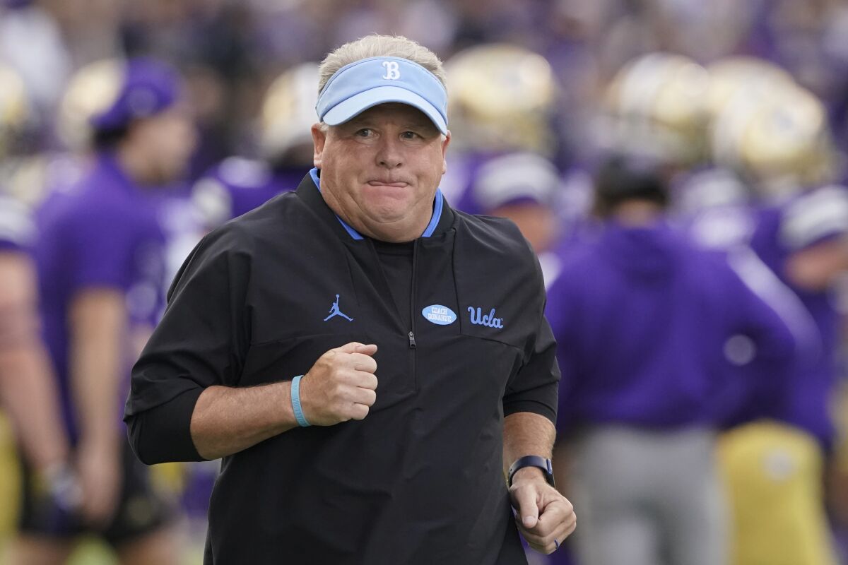 UCLA head coach Chip Kelly runs on the field before a game.