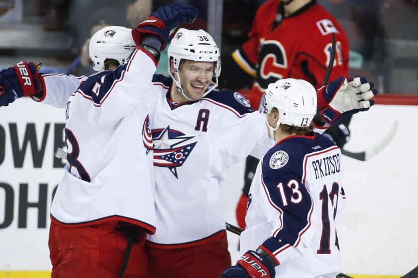 Columbus Blue Jackets' Boone Jenner, center, celebrates his goal with teammates David Savard, left, and Cam Atkinson during the first period against the Calgary Flames on Friday.