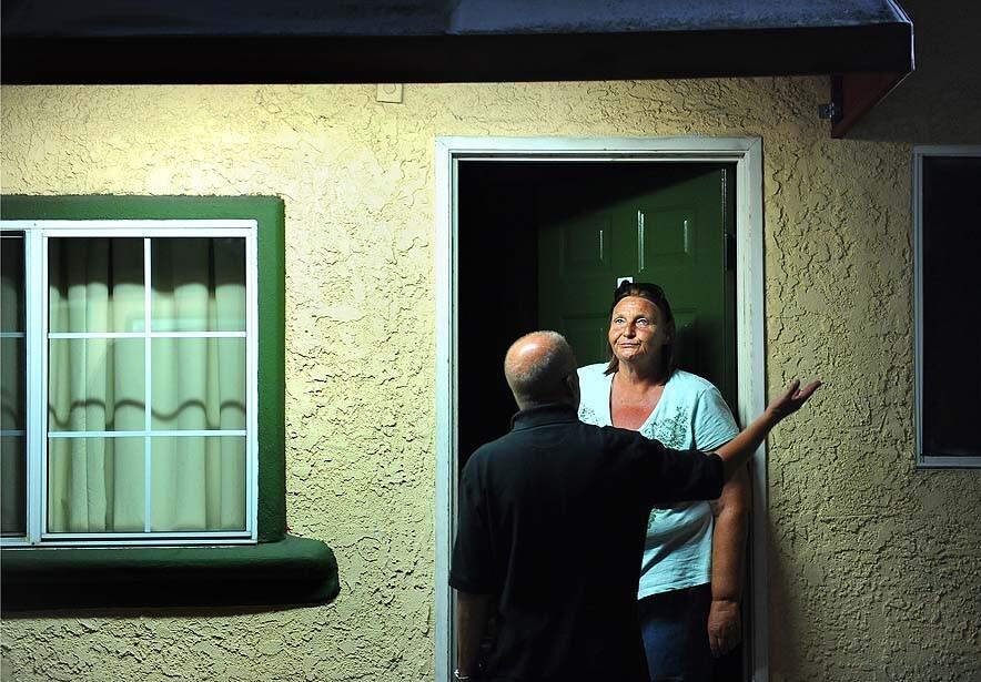 Patient Laura Jurgenson talks with healthcare worker Roy Kaufman outside her motel room. A nonprofit has leased out the motel to use as a recuperative care center for homeless people just released from area hospitals. See full story