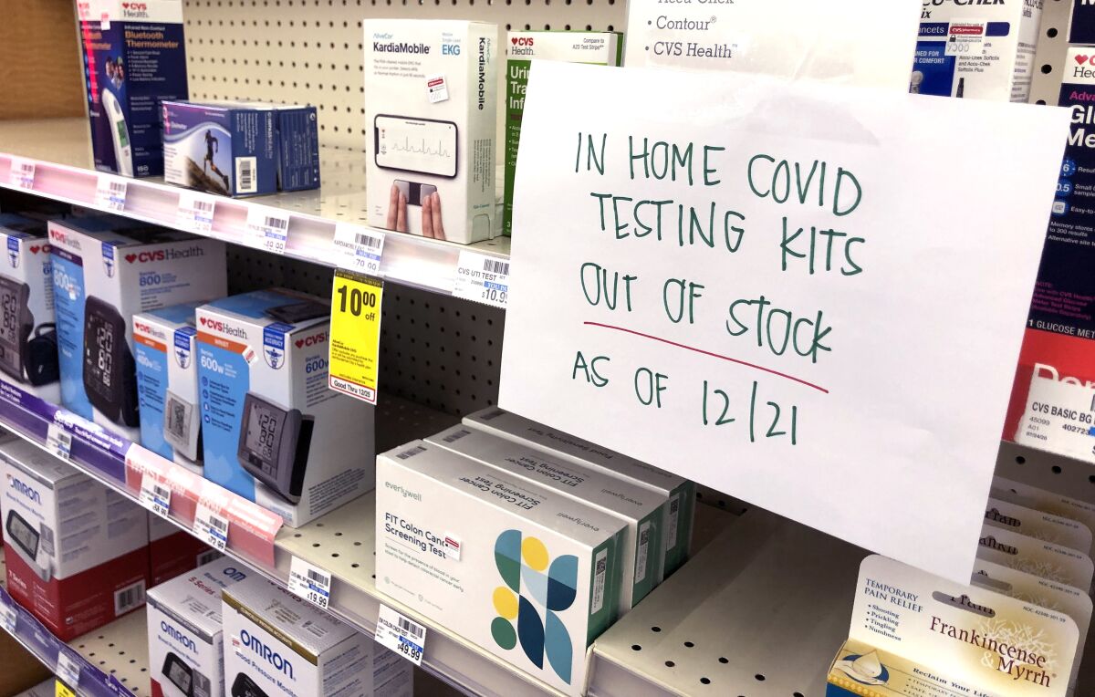 "In home testing kits out of stock as of 12/21" reads a sign on a drug store shelf 