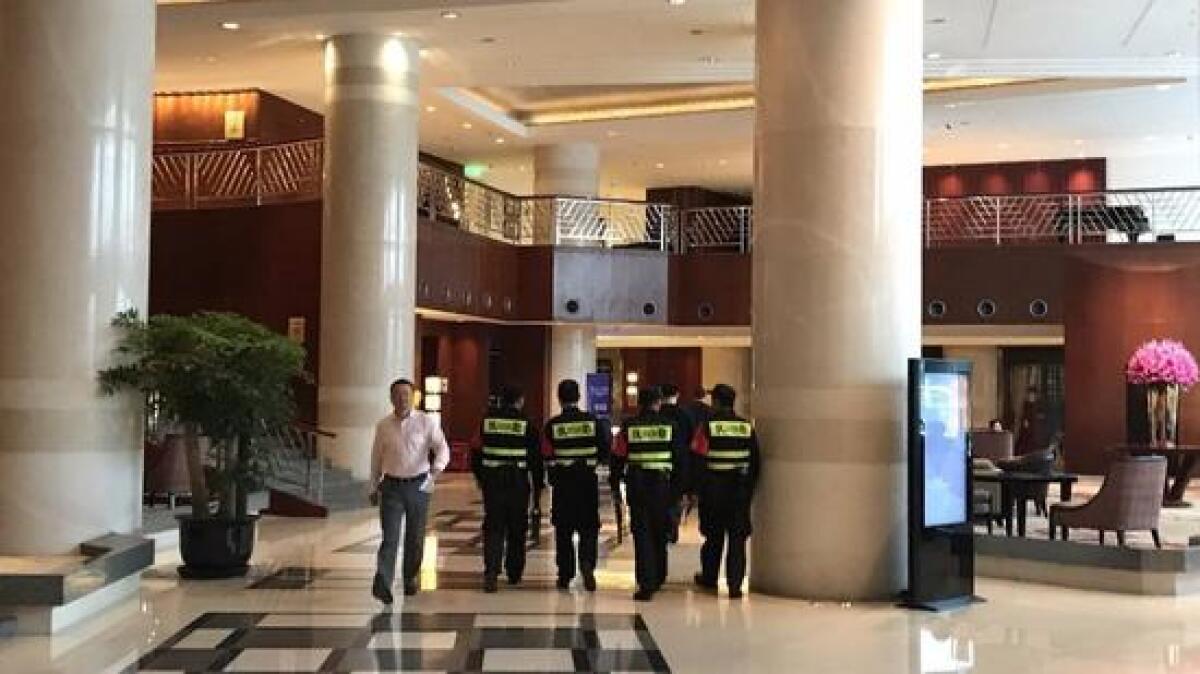 Security guards walk through the hotel in Hangzhou, China, where three UCLA basketball players are staying.