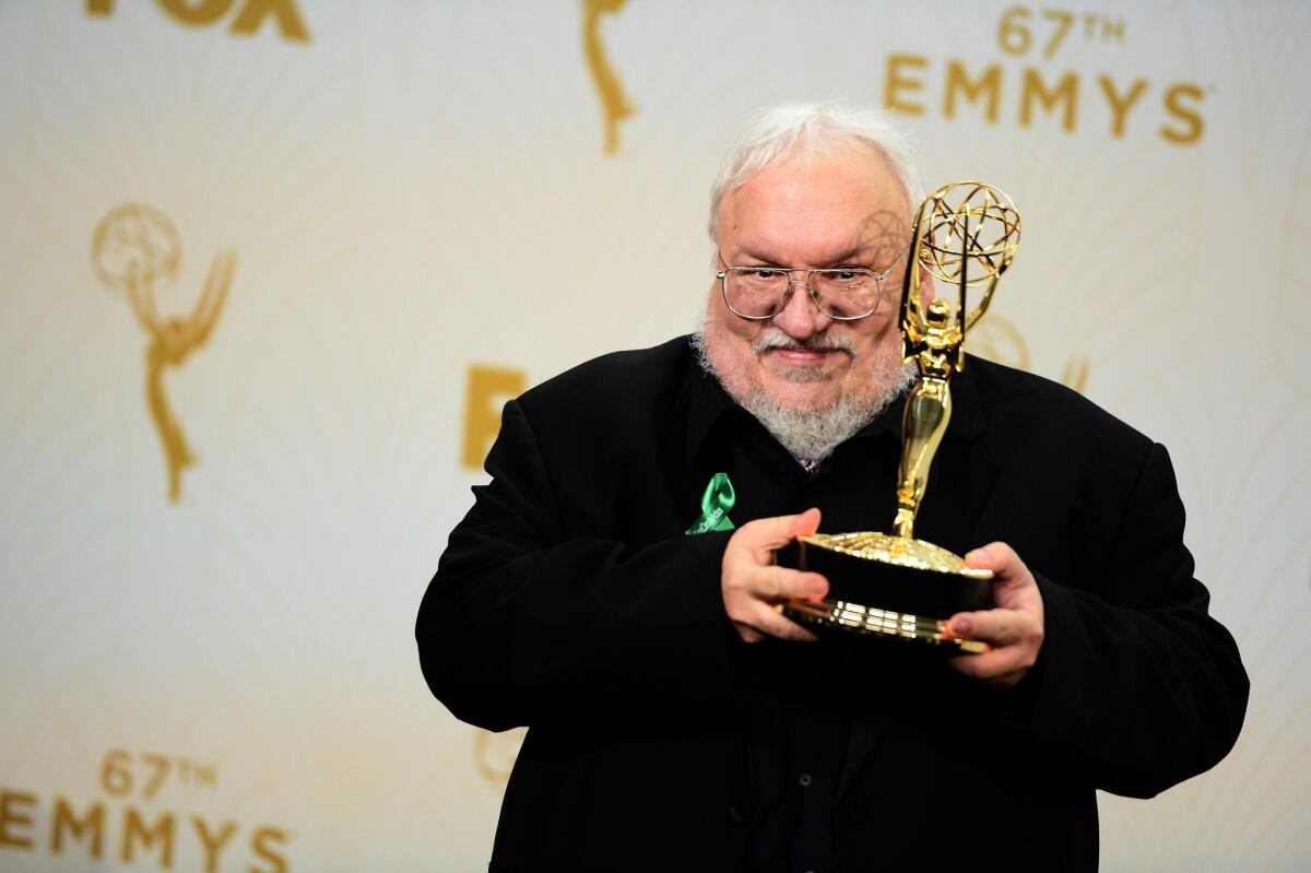 George R.R. Martin holds up an Emmy he won for "Game of Thrones" in 2015.