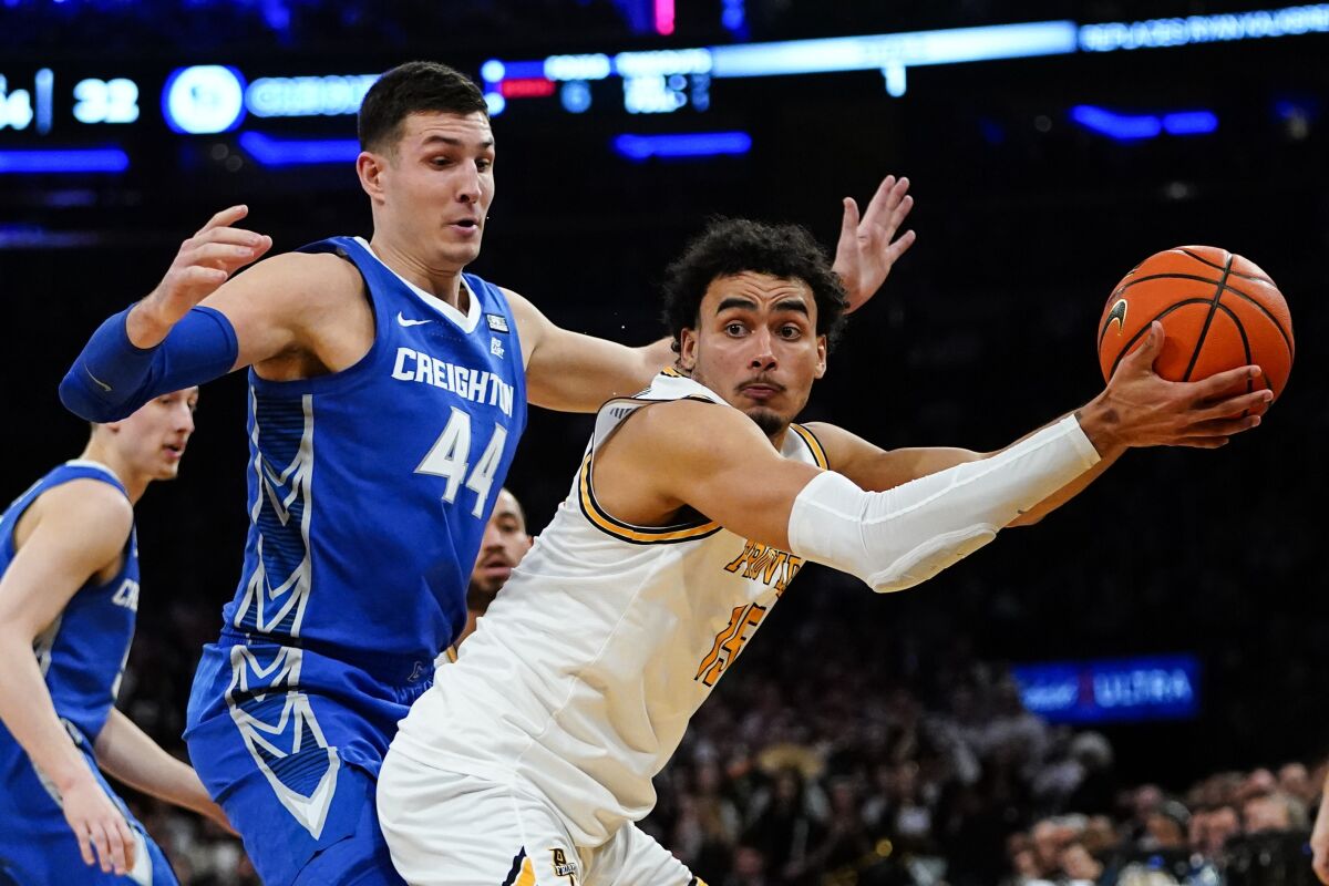 Providence's Justin Minaya, right, protects the ball from Creighton's Ryan Hawkins (44) during the first half of an NCAA college basketball game in the semifinals of the Big East men's tournament Friday, March 11, 2022, in New York. (AP Photo/Frank Franklin II)