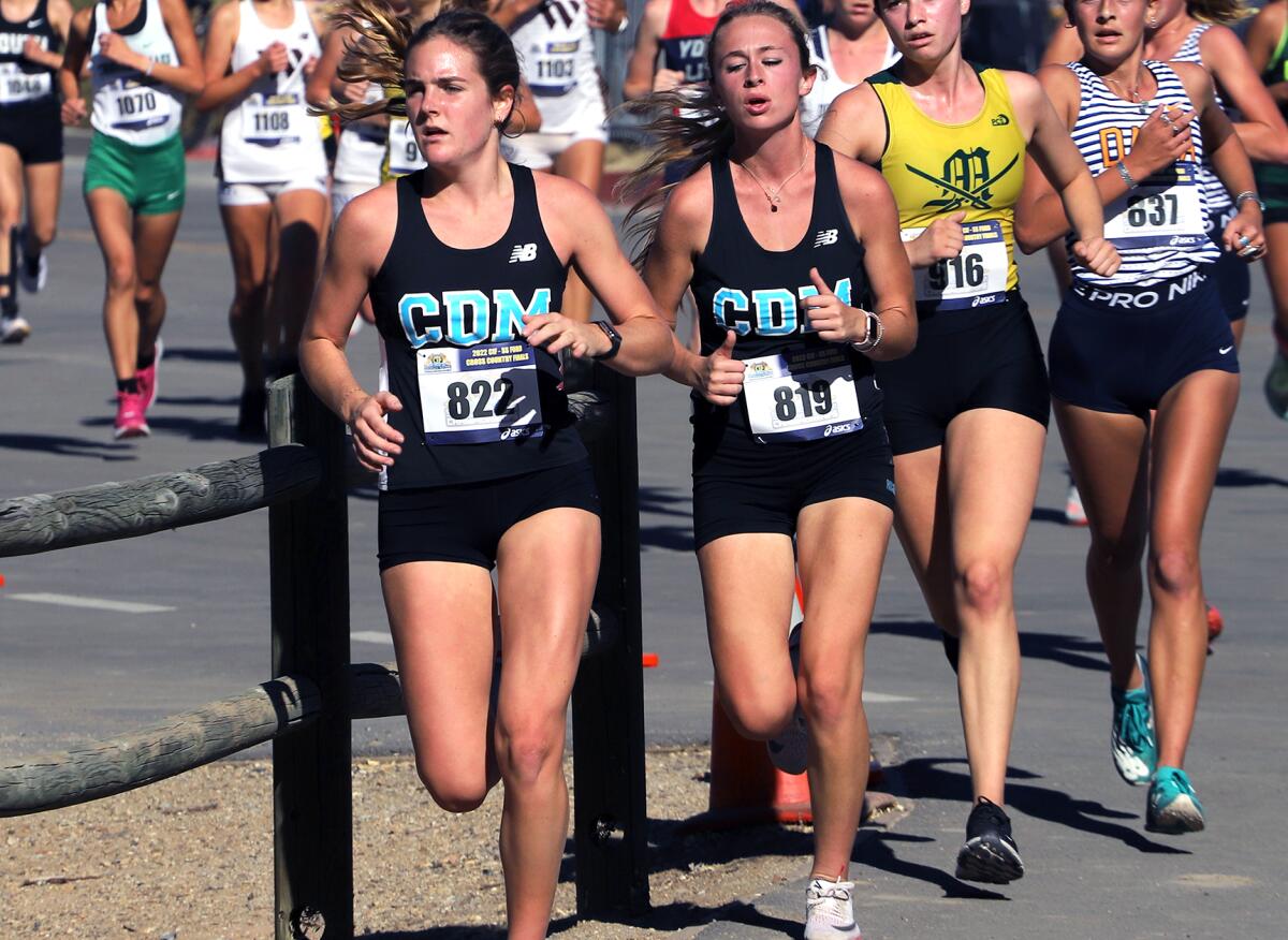 Corona del Mar's Ellie Rosing (822) and Bea Douglass (819) run in the girls' Division 3 race of the CIF finals on Saturday.