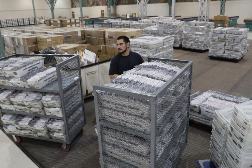 A worker moves ballots at a county facility in the City of Industry.