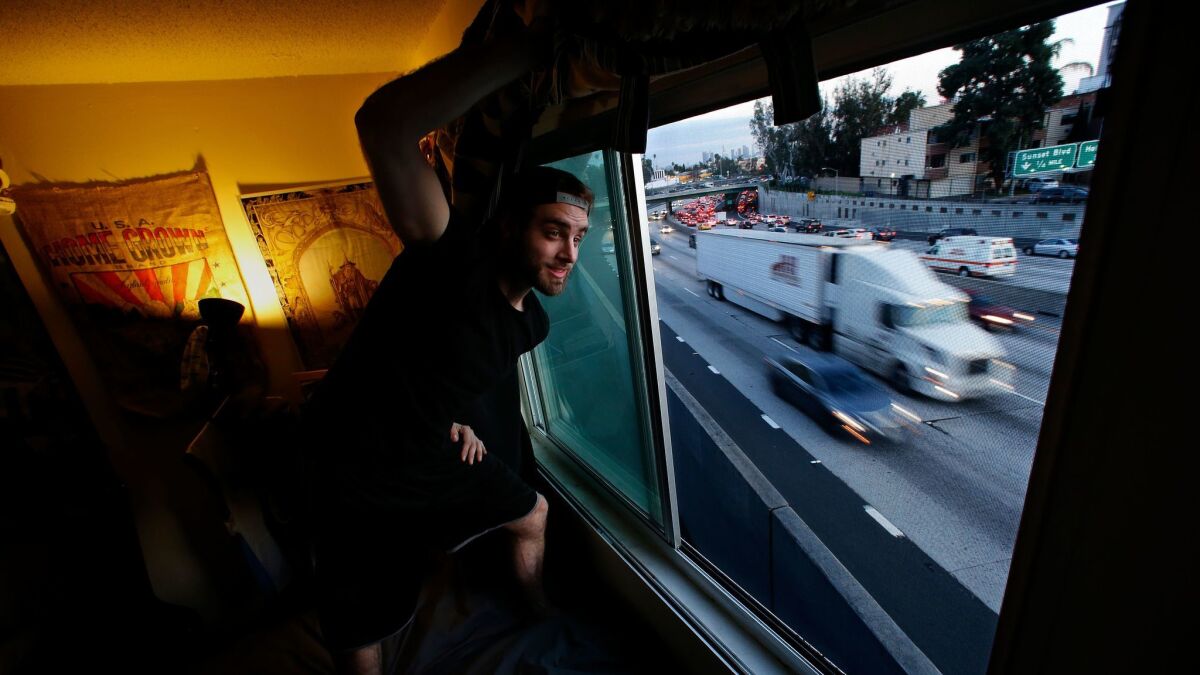 Mason Miller keeps a blanket over the window of his apartment overlooking the 101 Freeway in Hollywood. More than 1.2 million people live in high-pollution zones within 500 feet of a Southern California freeway.