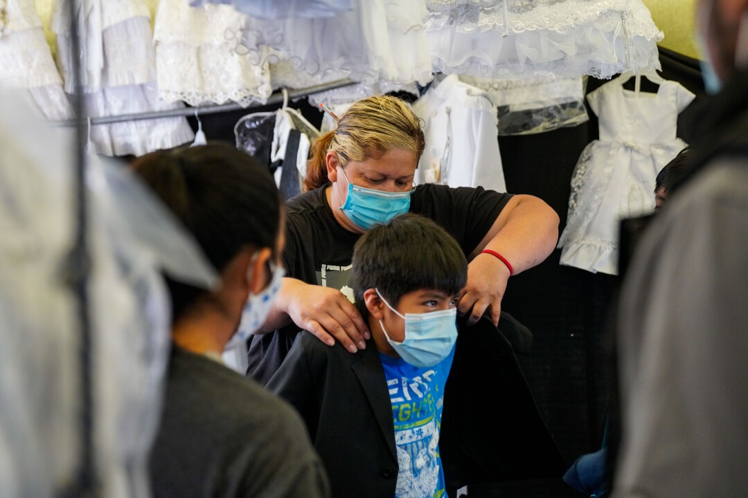 Elizabeth Vargas helps a customer with a fitting at her stall at the Paramount Swap Meet.