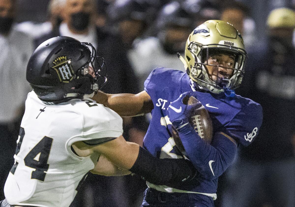 St. John Bosco running back Rayshon Luke tries to break a tackle by Servite defensive back Nick Jako.